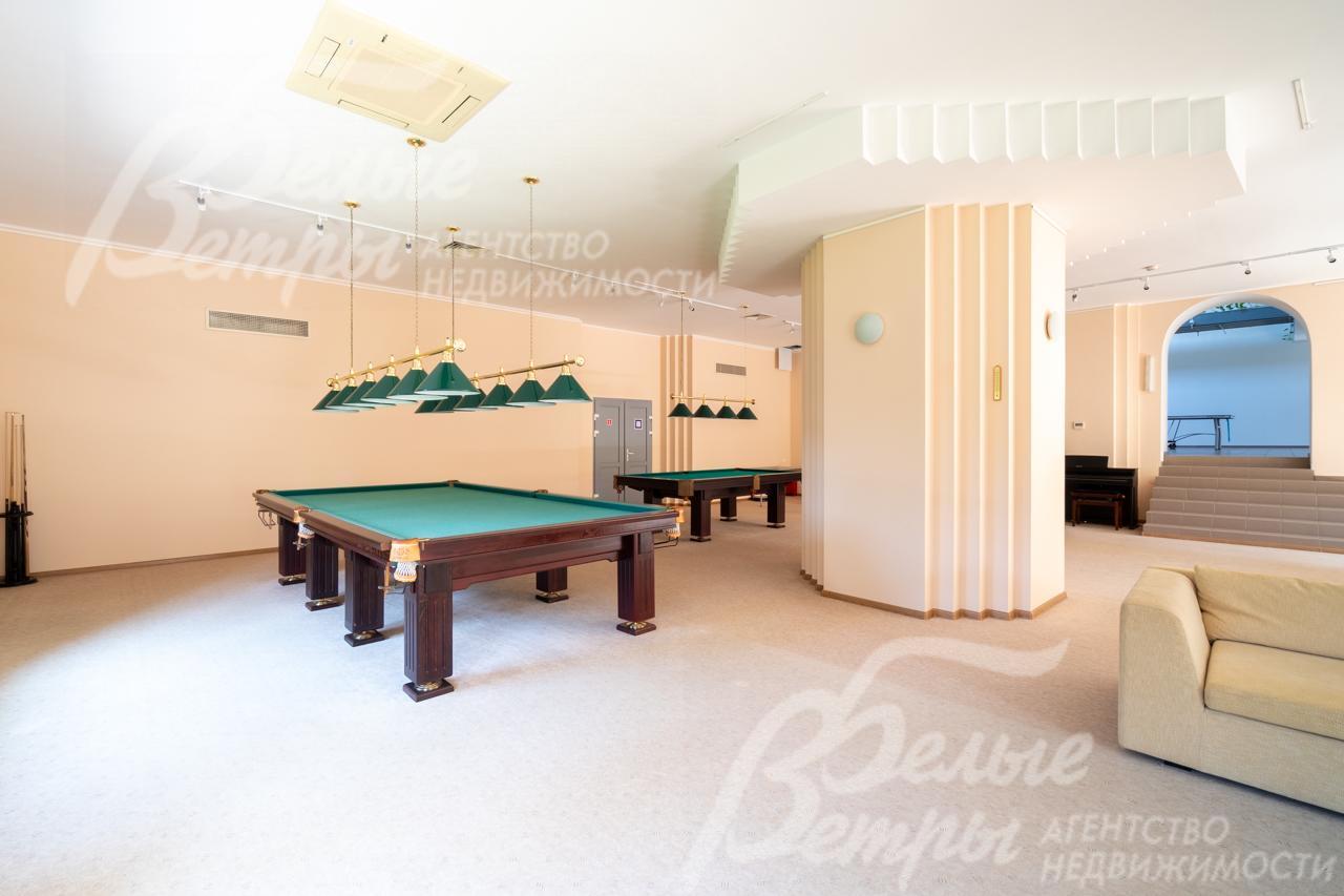 Бильярдный зал с несколькими столами.