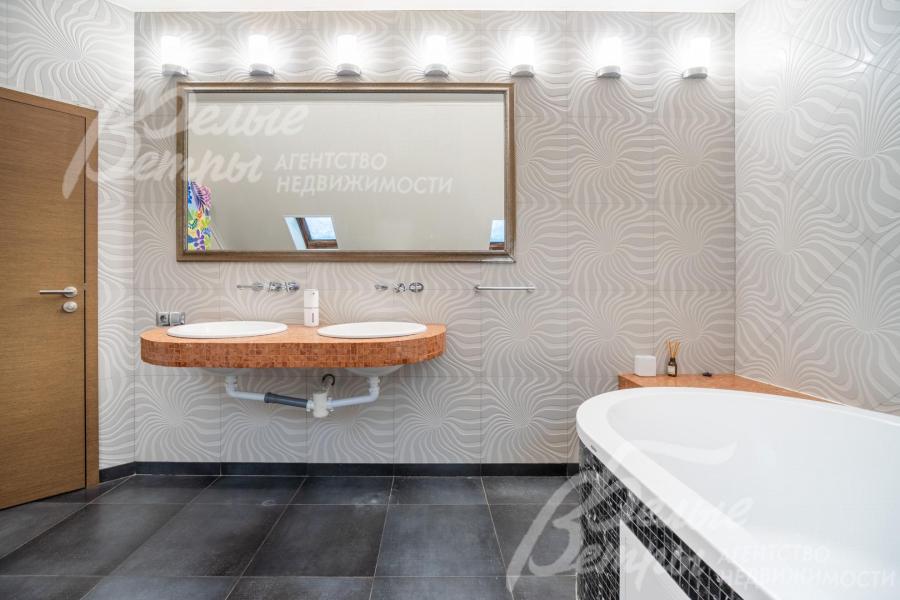 Пол выложен контрастной крупной тёмной плиткой с матовой поверхностью, двойная раковина - на подвесной конструкции
