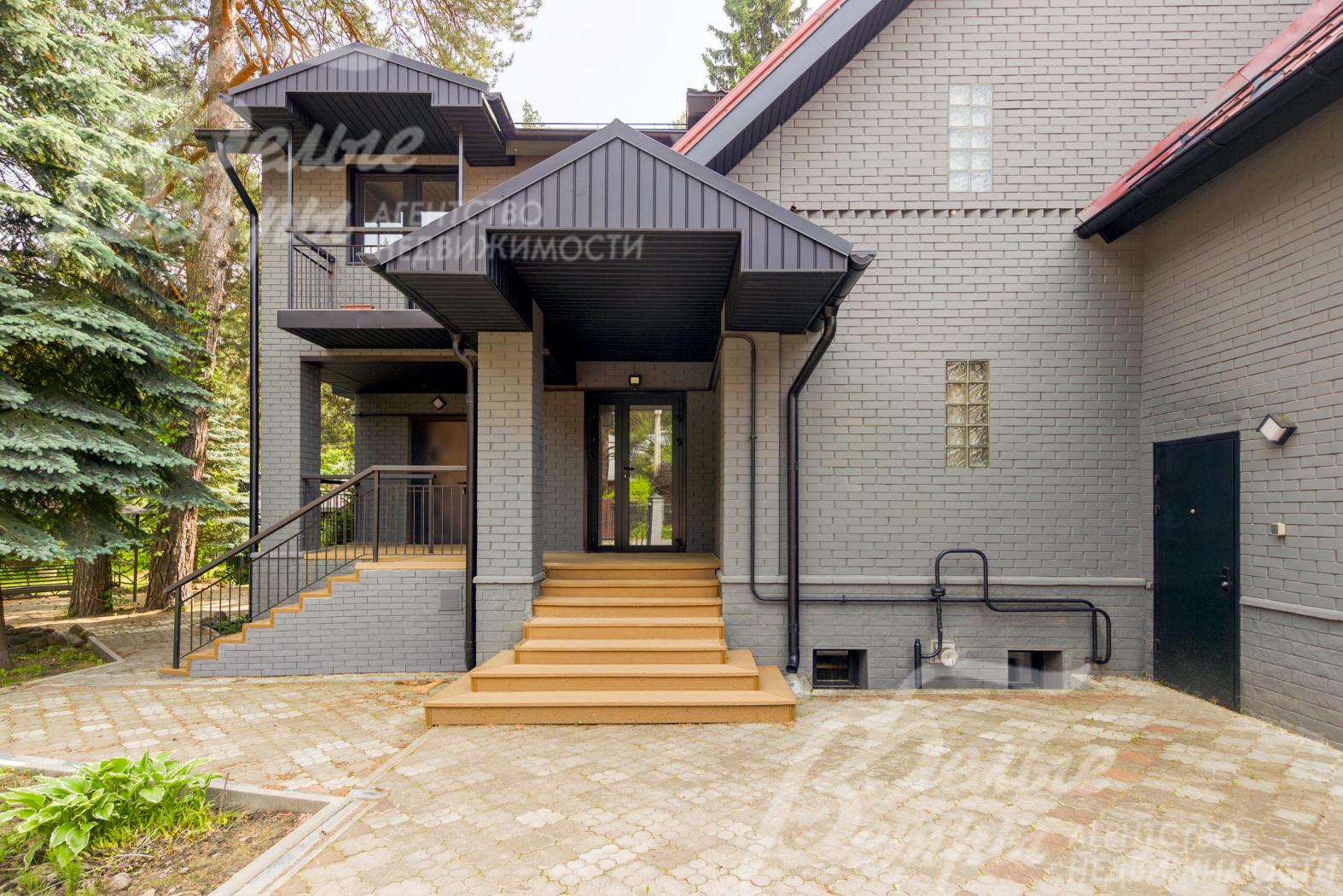Главный вход в дом. Цоколь отделан крашенным кирпичом, ступени крыльца - из древесно-полимерного композита