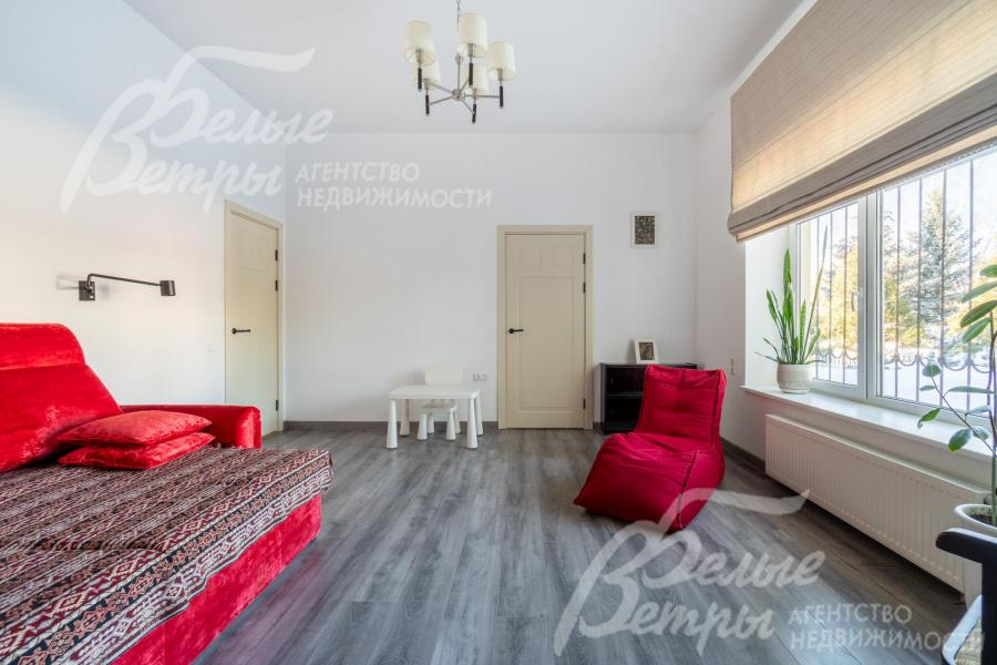 Мастер‑блок на первом этаже начинается с просторного кабинета, в котором стоят акцентные диван и кресла