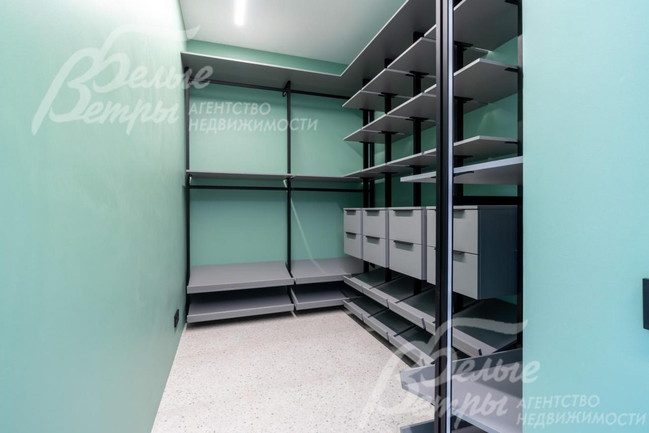 Гардеробная мастер-спальни оснащена удобной системой хранения