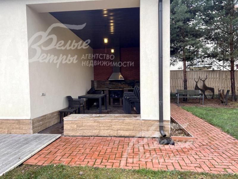 У дома есть крытая терраса с оборудованной зоной барбекю и садовой мебелью