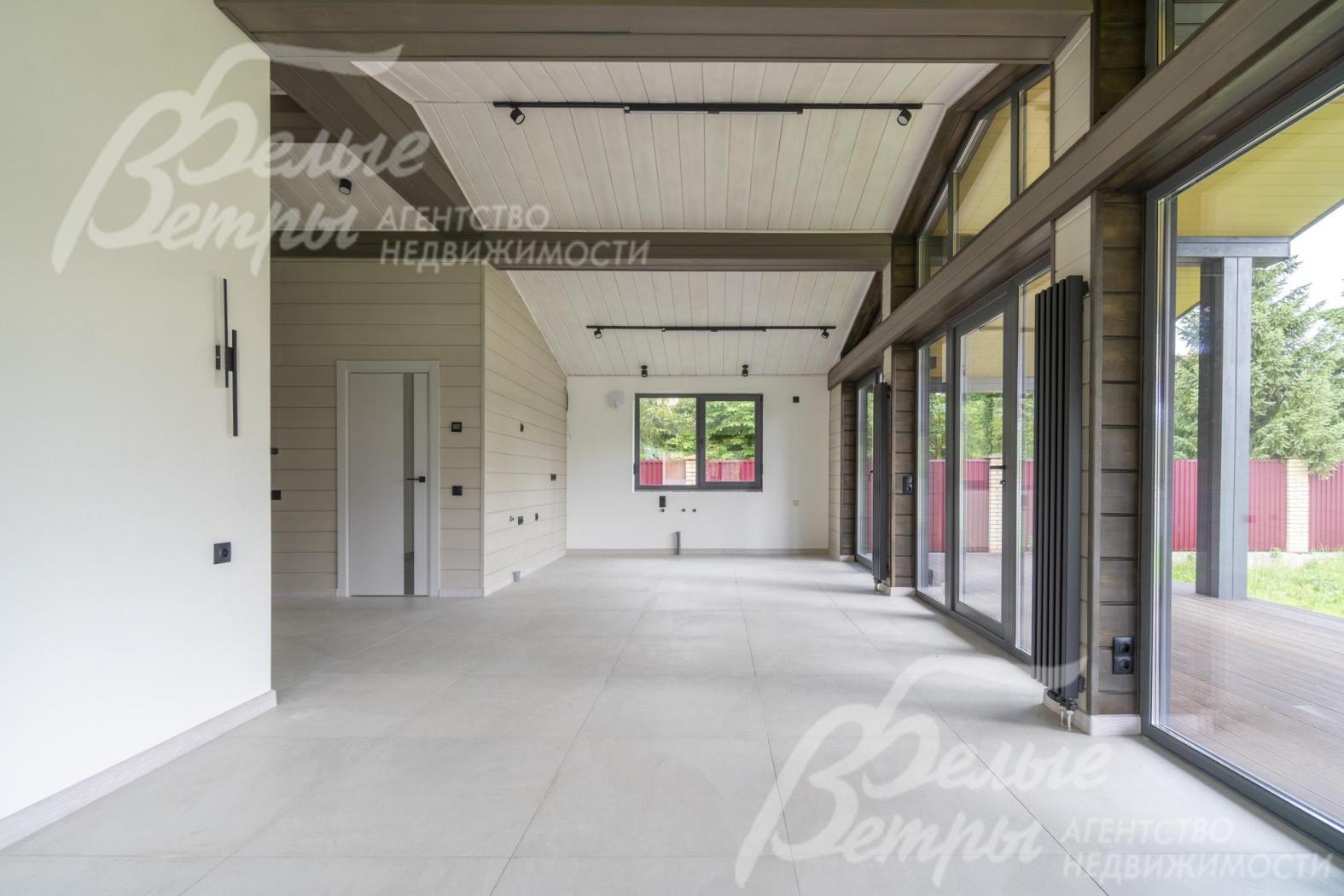 В доме - панорамное остекление (энергоэффективный профиль BRUSBOX), на потолках - балки из дерева темного цвета