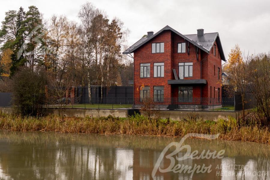 Вид на дом и участок с другого берега пруда: дом гармонично вписан в природный ландшафт