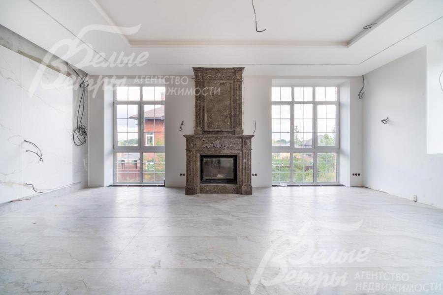 Эффектный камин с порталом в классическом стиле от пола до потолка, отделанным коричневым мрамором