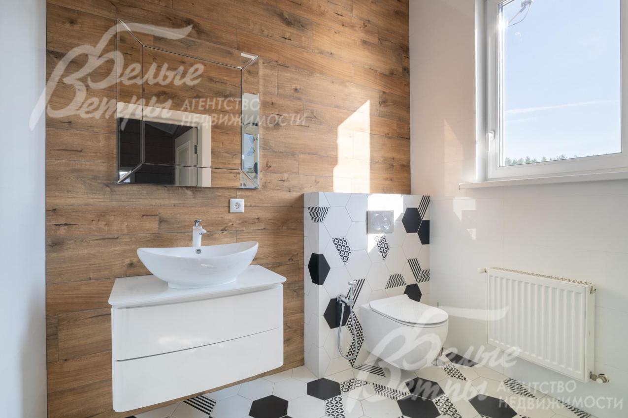 Санузел на втором этаже с окном и акцентной стеной, оформленной плиткой "под дерево"