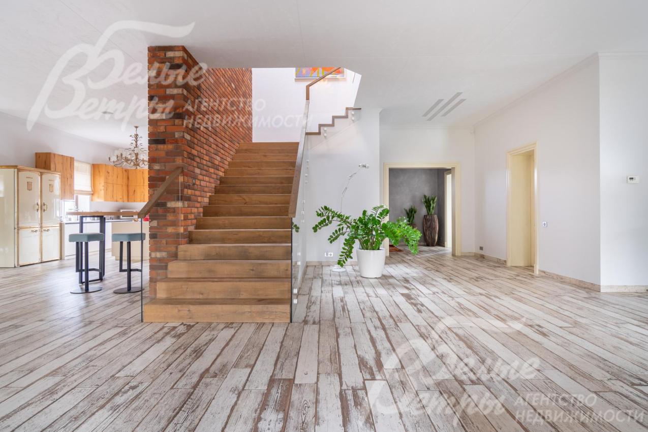 На второй этаж ведёт широкая лестница со ступенями, отделанными инженерной доской FINEX (дуб), стеклянным ограждением и поручнями FINEX