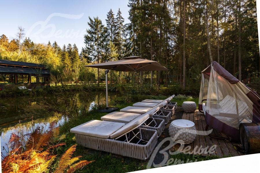 Возле пруда оборудована зона отдыха с шезлонгами. Через водоём перекинуты изящные мостики, завершающие облик пространства