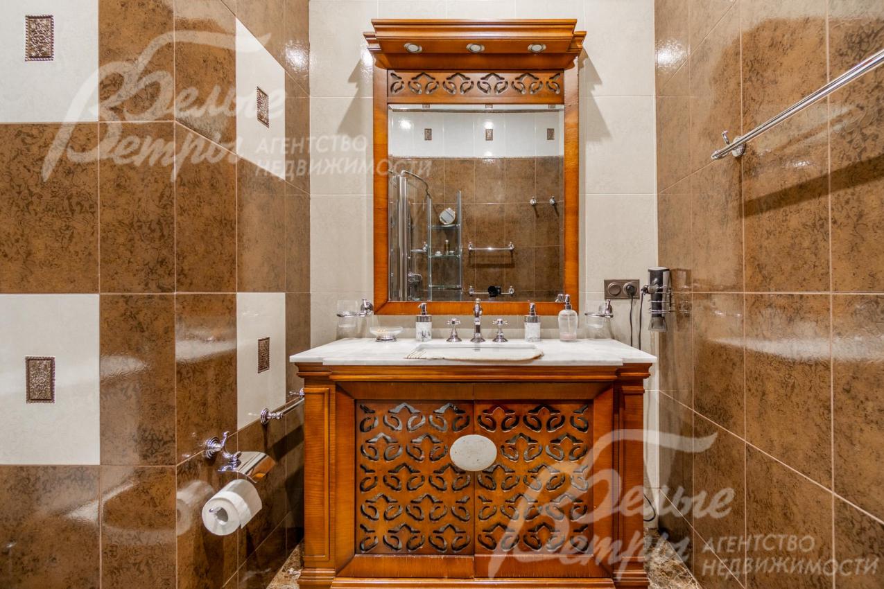 Раковина интегрирована в тумбу с зеркалом из массива дерева