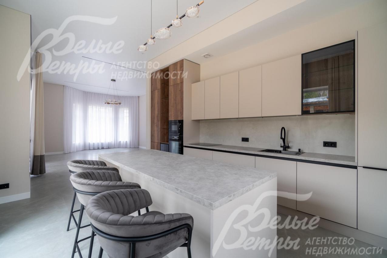 Из гостиной-столовой – свободный архитектурный переход на кухню с функциональным зонированием светом