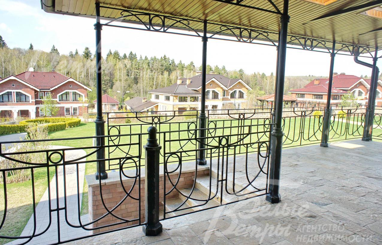 Терраса с коваными перилами и видом на участок