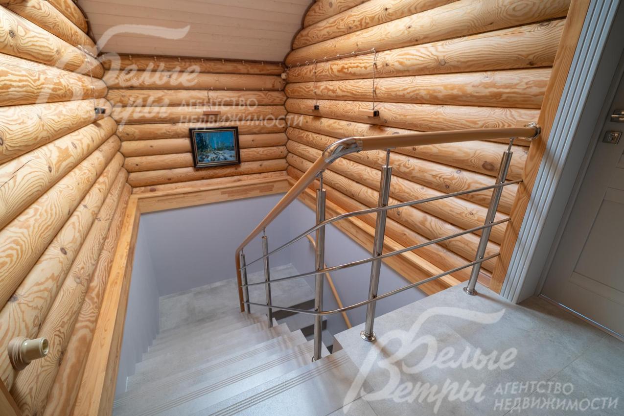 Лестница на второй этаж выполнена на бетонном основании: ступени – из керамогранита, а ограждение — металлическое с деревянным поручнем