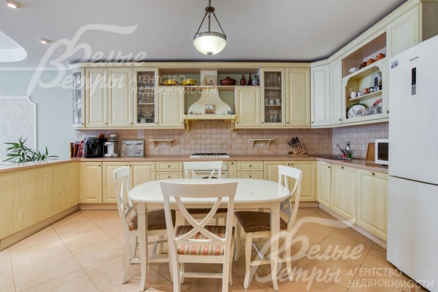 На кухне установлен итальянский гарнитур молочного цвета и обеденная группа в тон гарнитура