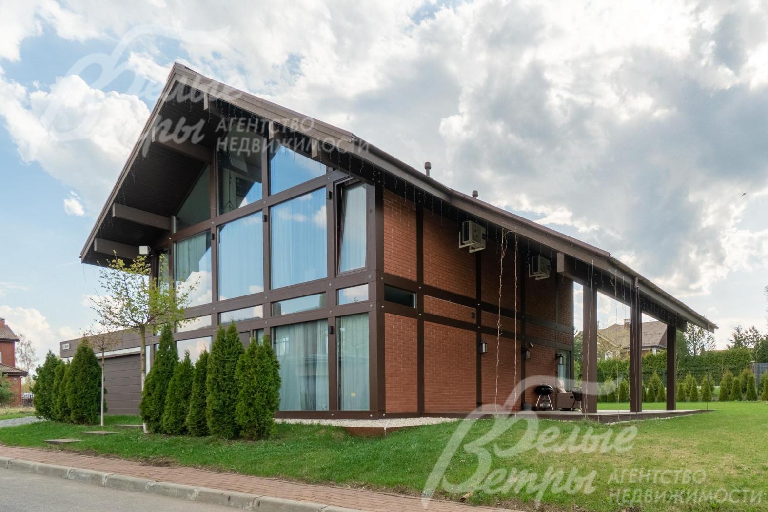 У главного входа в дом высажены туи