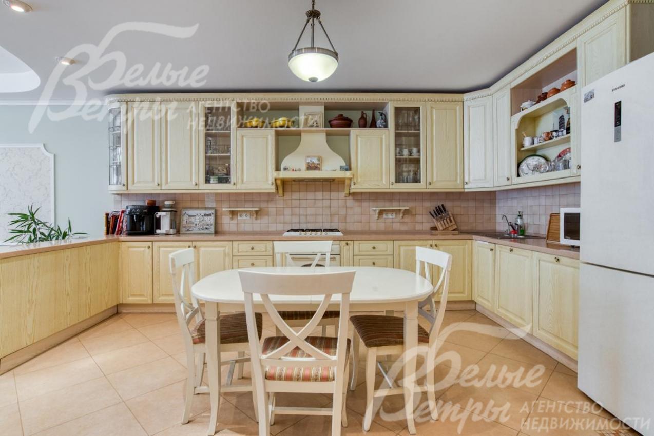 На кухне установлен итальянский гарнитур молочного цвета и обеденная группа в тон гарнитура