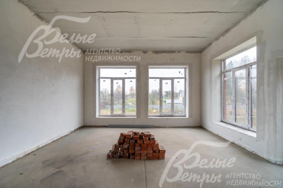 Зона гостиной. В доме много больших окон, наполняющих помещения естественным светом