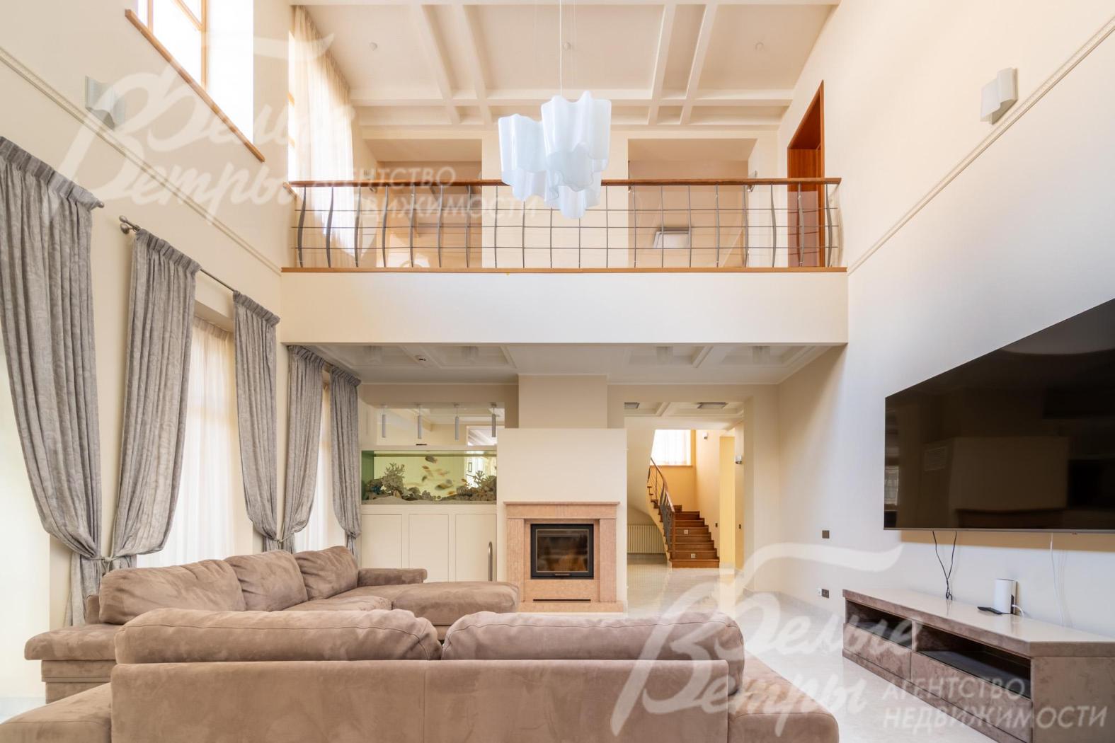 Гостиная наполнена светом, стильная отделка в тёплых светло‑бежевых нейтральных тонах добавляет уюта