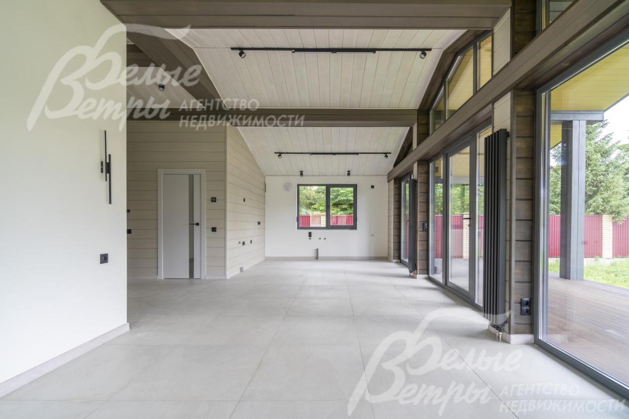 В доме - панорамное остекление (энергоэффективный профиль BRUSBOX), на потолках - балки из дерева темного цвета