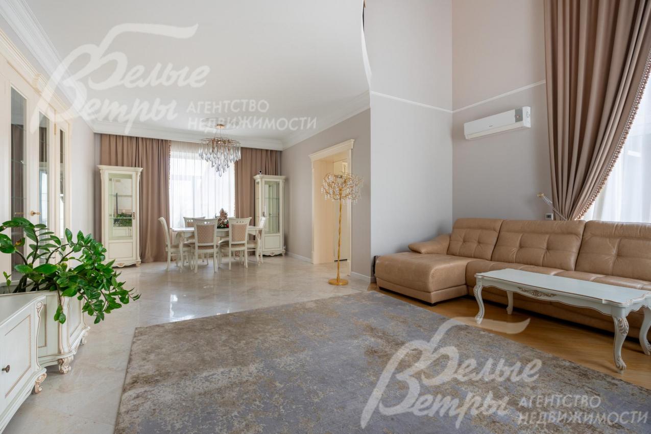 Гостиная и столовая, разделённые декоративной стенкой, оформлены в едином классическом стиле