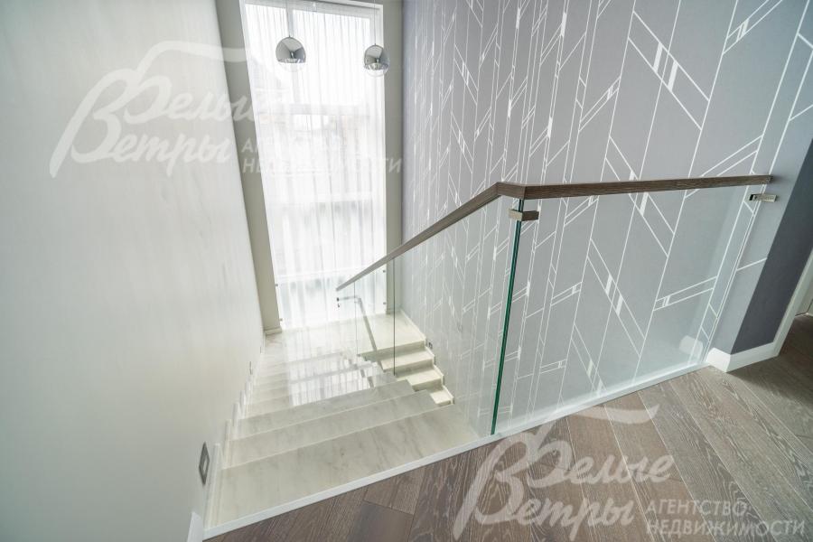 Большое окно за лестничным проёмом наполняет оба этажа дома естественным светом