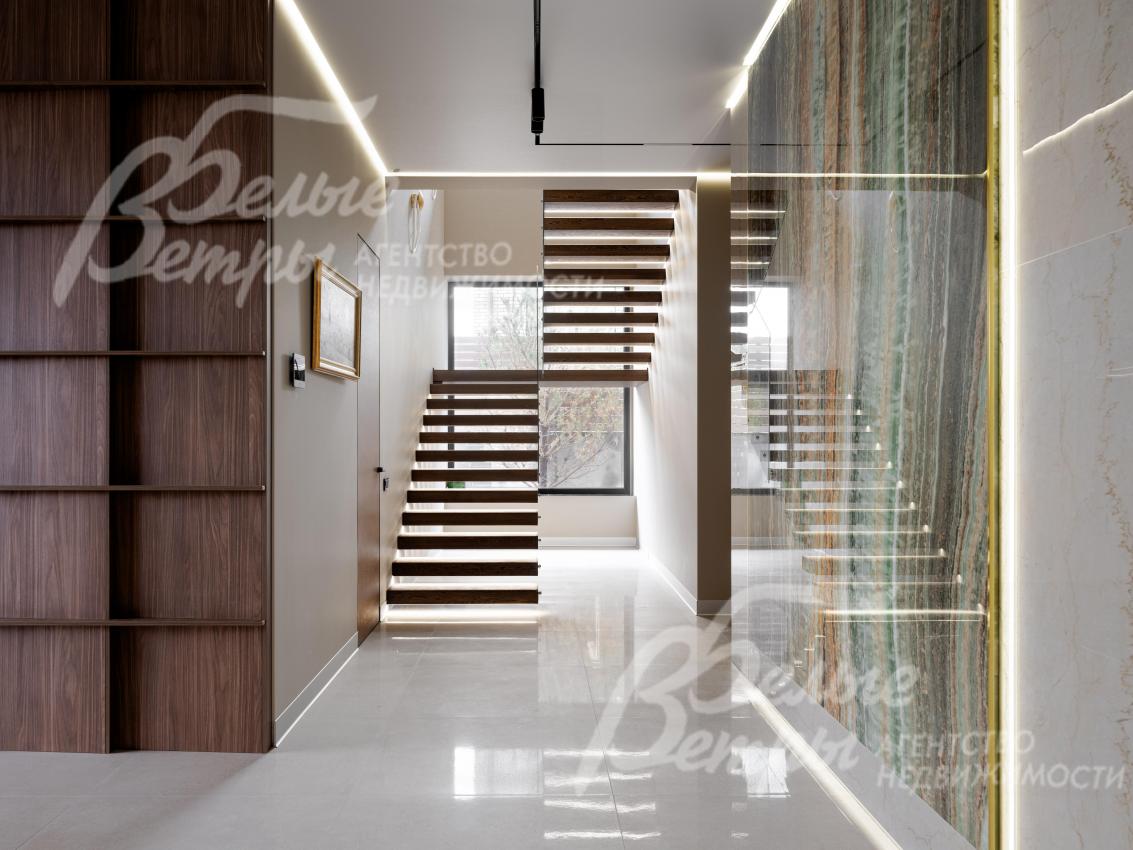 На второй этаж ведёт «парящая» лестница с подсветкой в основании, ступенями из шпона дуба и стеклянным ограждением