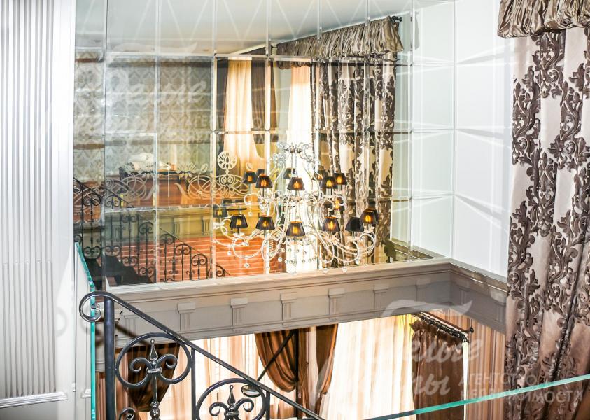 В гостиной на втором свете стена выполнена из зеркал и ней прикреплено бра, что дает, днем больше дневного света из окон, а вечером отраженное бра создает эффект люстры.