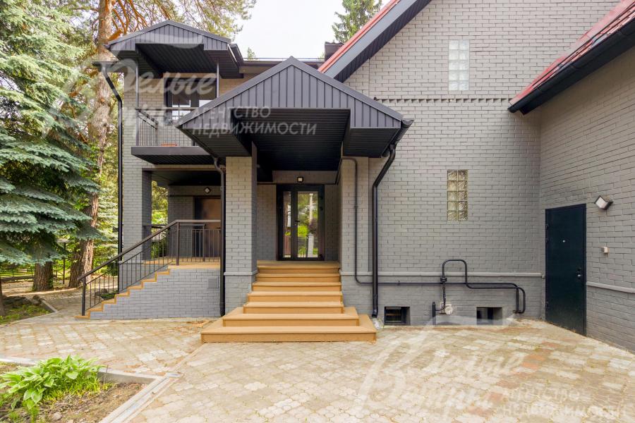 Главный вход в дом. Цоколь отделан крашенным кирпичом, ступени крыльца - из древесно-полимерного композита