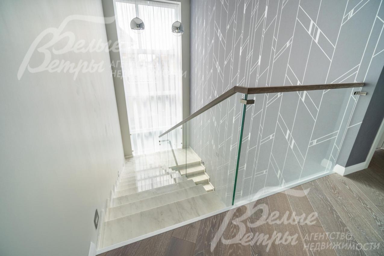 Большое окно за лестничным проёмом наполняет оба этажа дома естественным светом