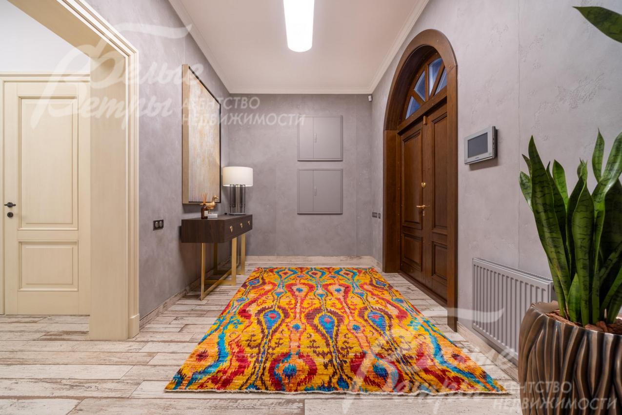 Прихожая дома. Входная двухстворчатая дверь с арочным окном утеплена и отделана панелями из массива дуба