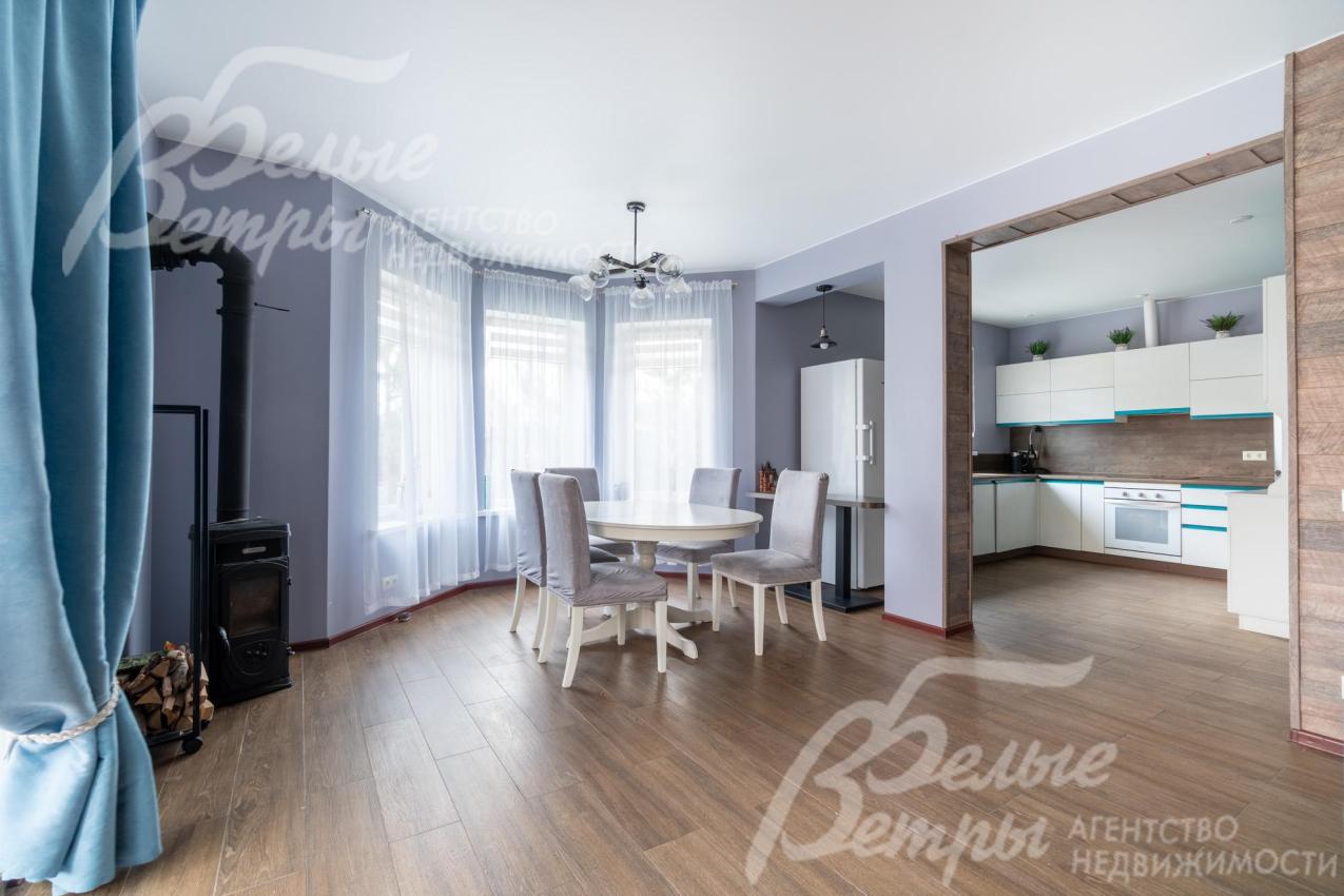 В зоне столовой - стол на 8 персон со стульями возле элегантного эркера