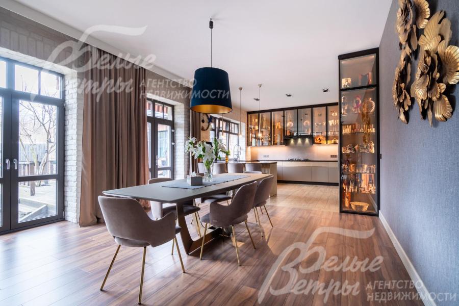 В зоне столовой, органично продолжающей дизайн гостиной, размещена обеденная группа. Слева - выход на террасу