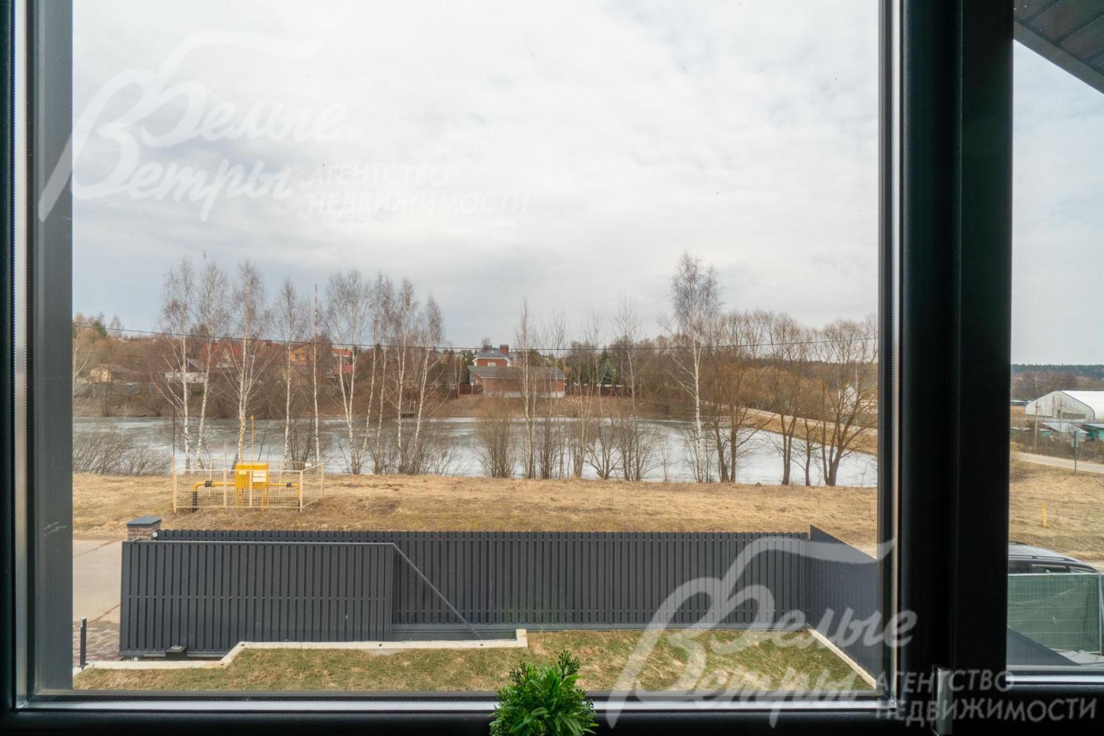 Из мастер-спальни открывается вид на пруд рядом с домом