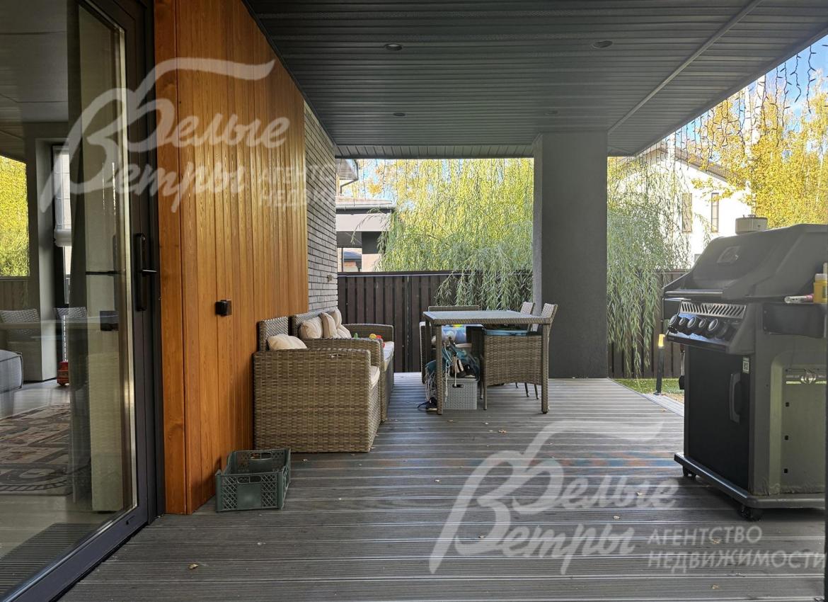 На террасе установлена садовая мебель и мангал