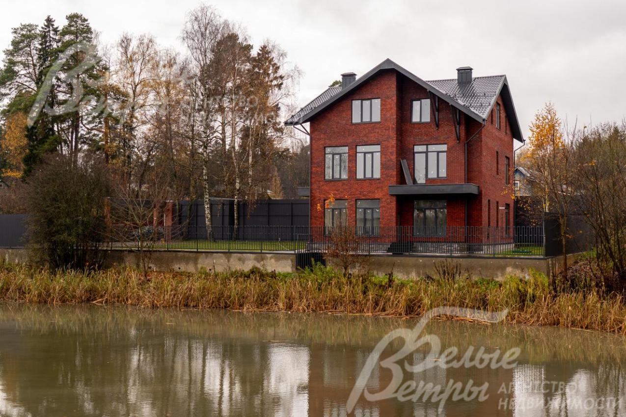 Вид на дом и участок с другого берега пруда: дом гармонично вписан в природный ландшафт