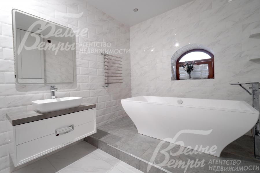 Стильный санузел в серо-белой палитре, белая ванна подчёркивает статусность интерьера