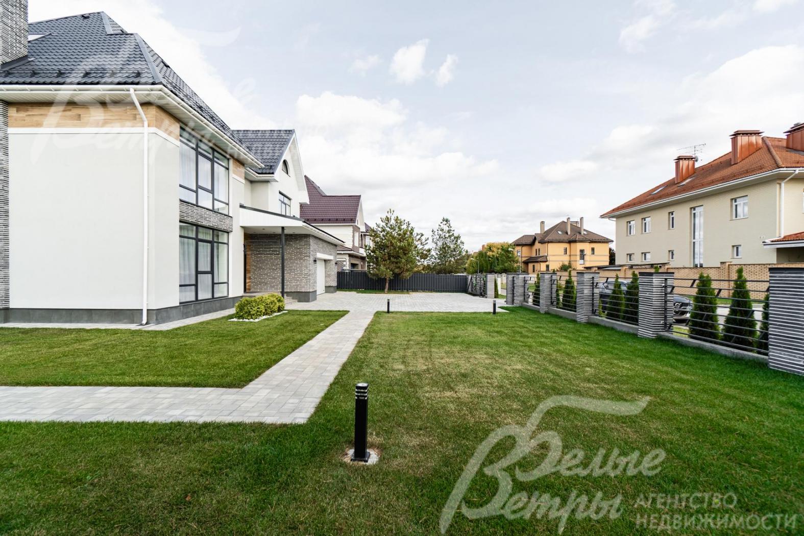 Участок огорожен спереди металлическим прозрачным забором на каменных столбах с бетонным цоколем, с других сторон - металлический забор с бетонным цоколем на металлических столбах