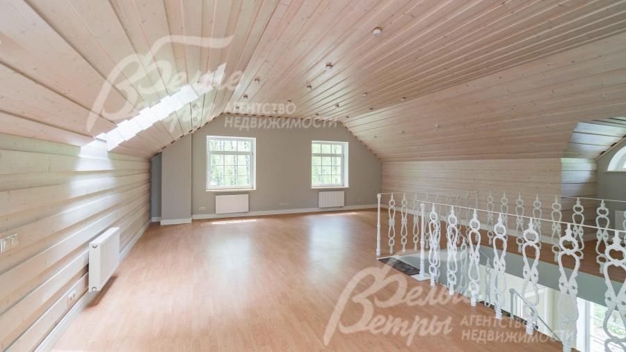 Мансардный этаж - с высокими потолками и множеством окон. Стены отделаны деревом в 3D раскладке