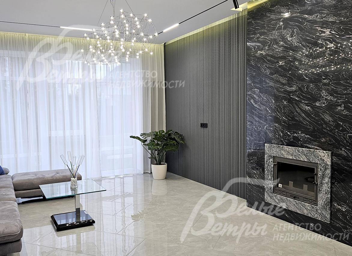 Гостиную украшает дровяной камин с большим порталом, отделанным натуральным мрамором