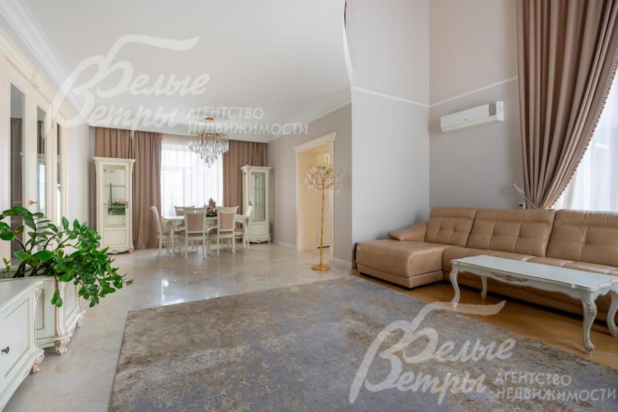 Гостиная и столовая, разделённые декоративной стенкой, оформлены в едином классическом стиле