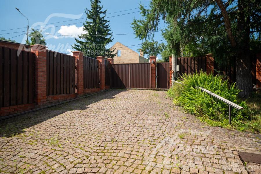 Парковка у дома выложена брусчаткой, на центральном въезде установлены откатные ворота