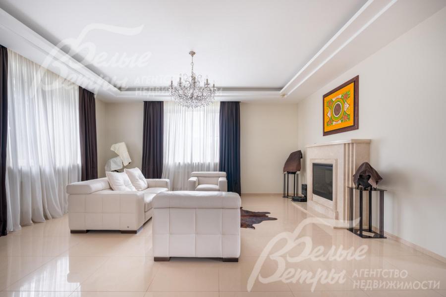 Также в гостиной - зона отдыха у камина: электрический камин с порталом шириной 1,7 м облицован натуральным бежевым мрамором