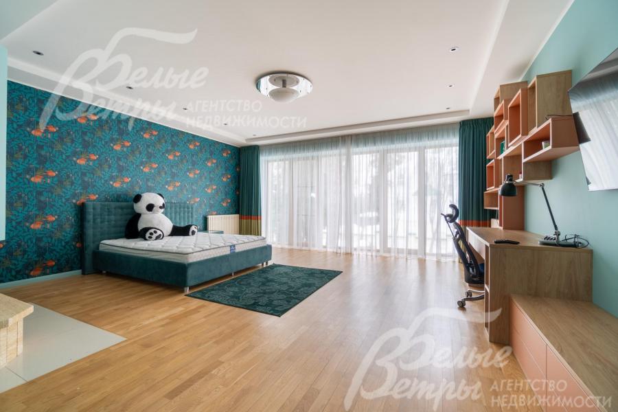 В интерьере детской спальни с панорамным остеклением светло-голубой цвет стен гармонично сочетается с тёмно-бирюзовыми акцентами, организовано функциональное рабочее место