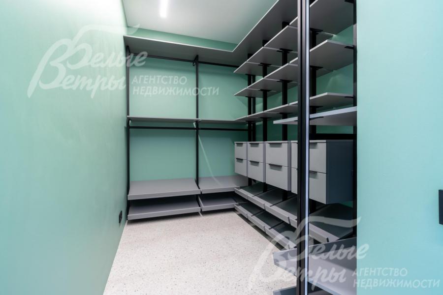 Гардеробная мастер-спальни оснащена удобной системой хранения