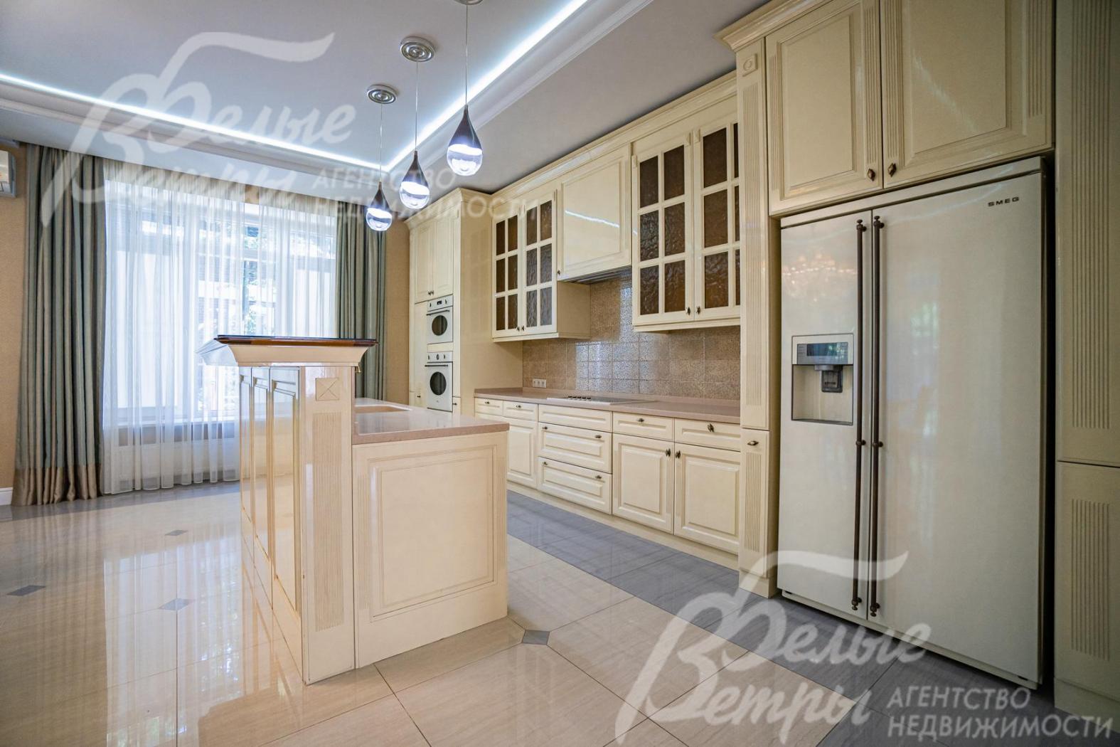 Фасады кухни - массив вишни, сливочного цвета, лакированные, с "золотой" резьбой 