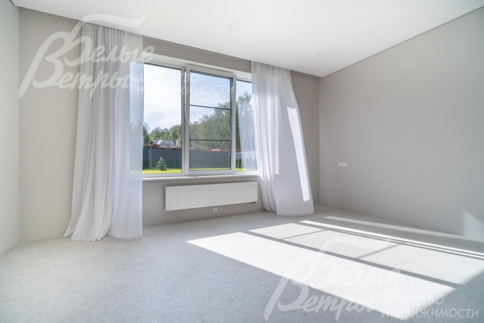 Просторная светлая спальня на первом этаже с большим окном