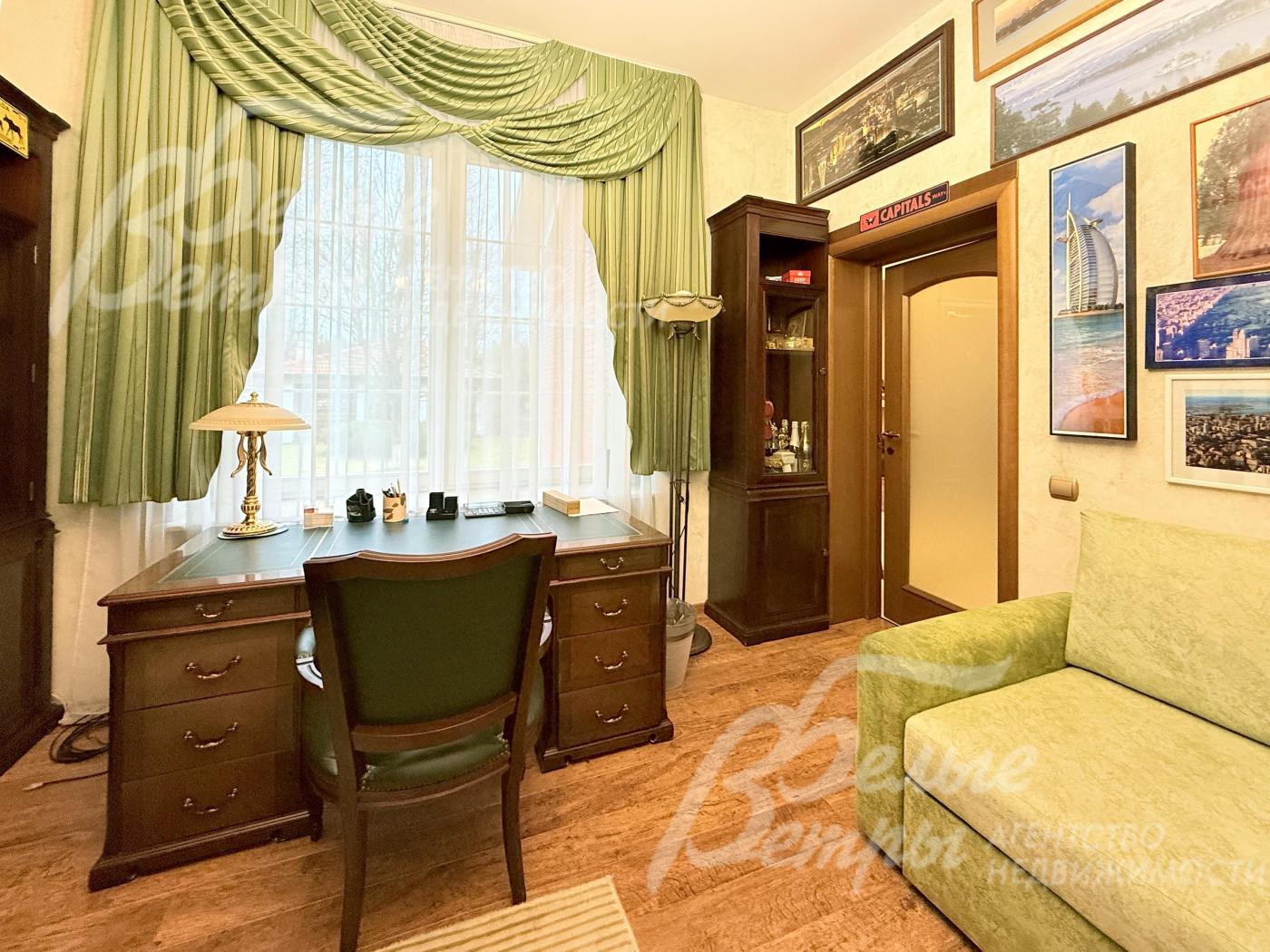 Одна из спален оборудована под кабинет, установлена классическая мебель из массива дерева и диван