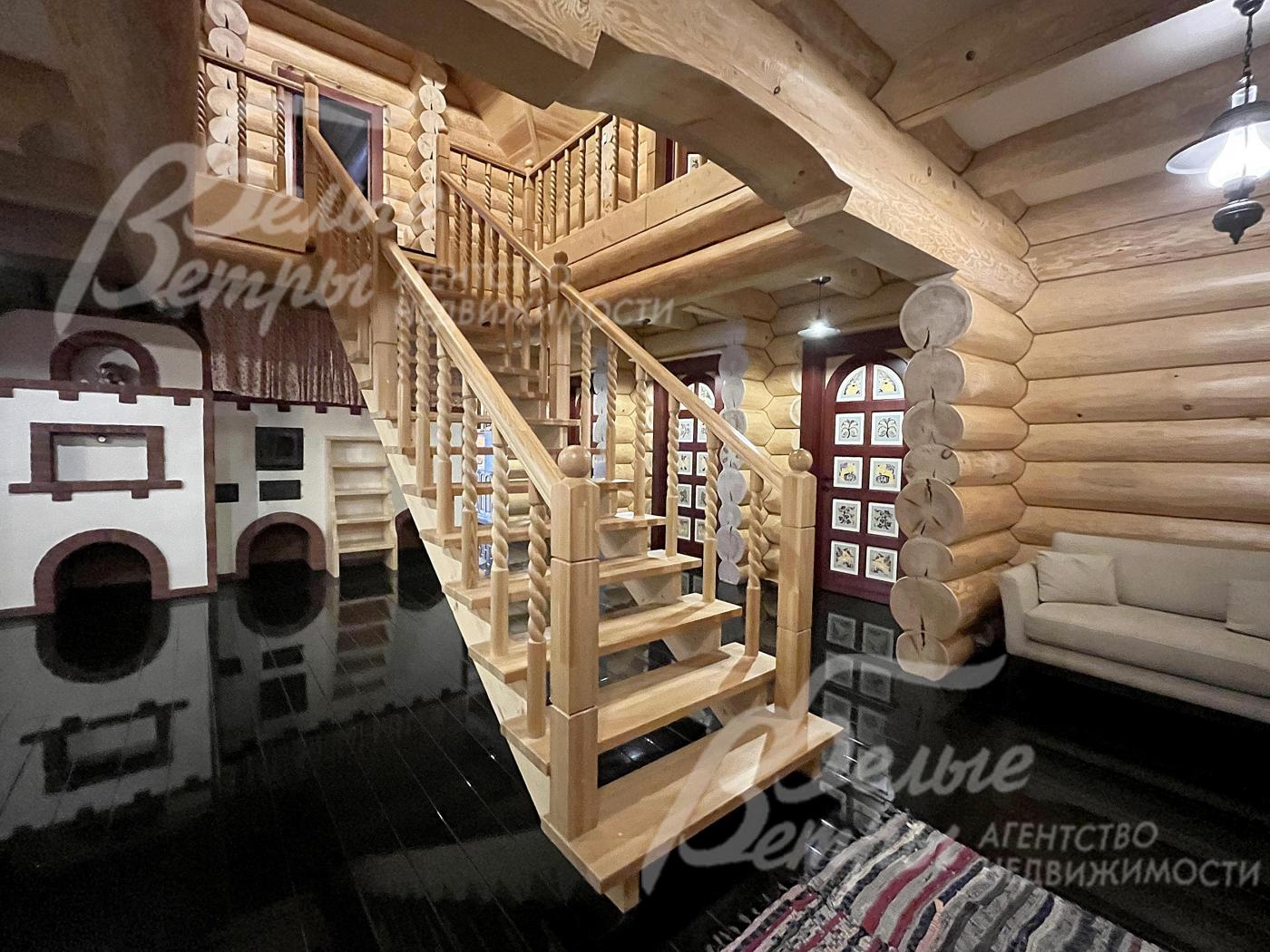 На второй этаж ведёт статная лестница из массива дерева с декоративными резными балясинами