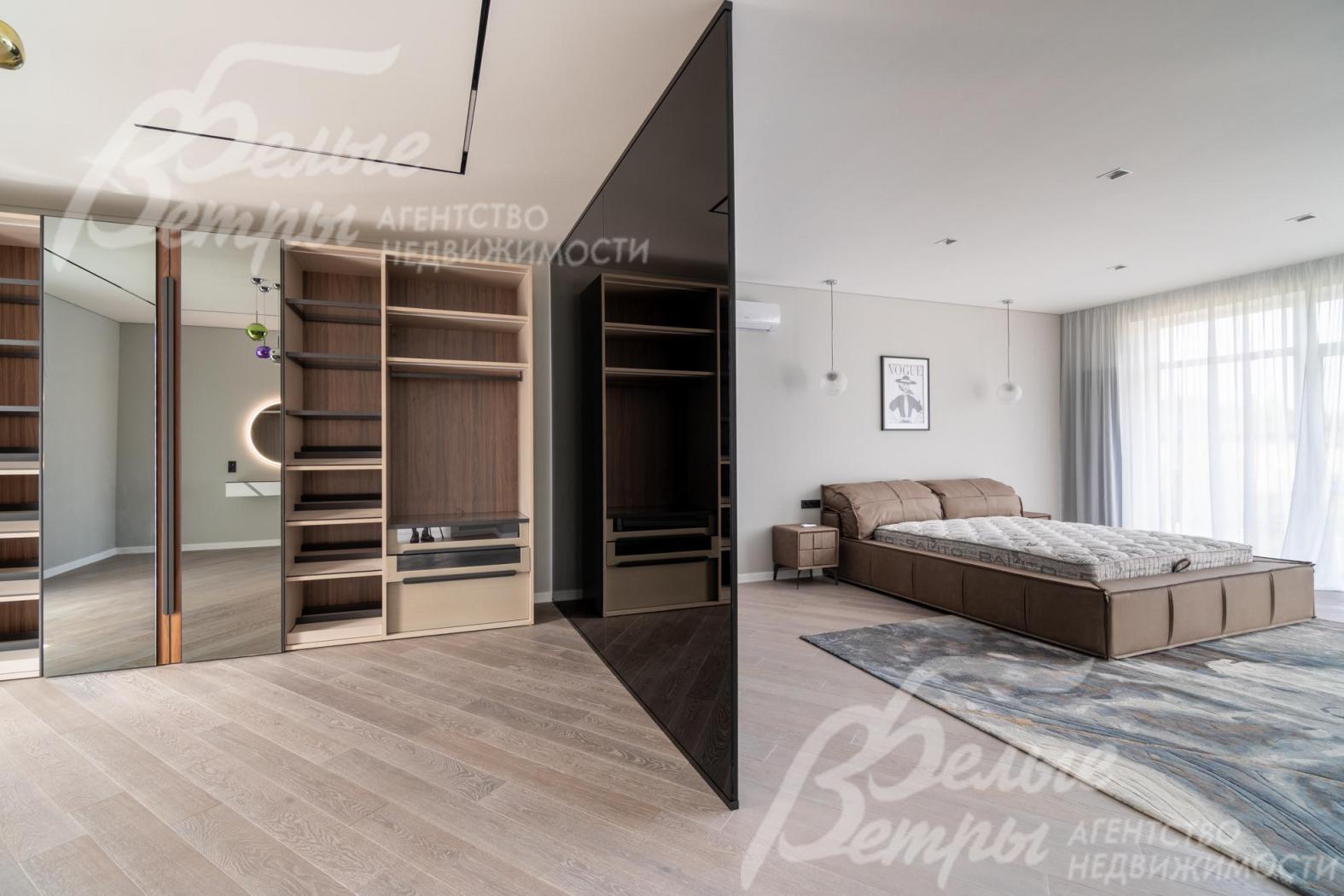 Гардеробная в мастер-спальне зонирована стеклянной тонированной перегородкой