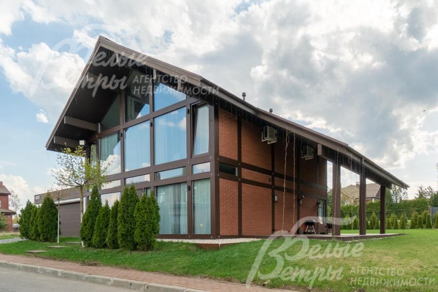 У главного входа в дом высажены туи