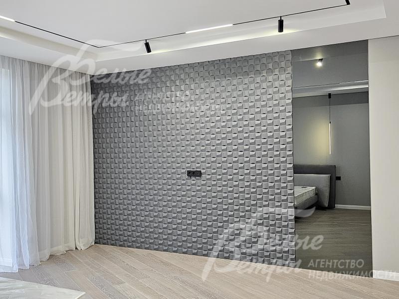 Декоративная перегородка с 3D-панелью разделяет спальную зону и гардеробную 